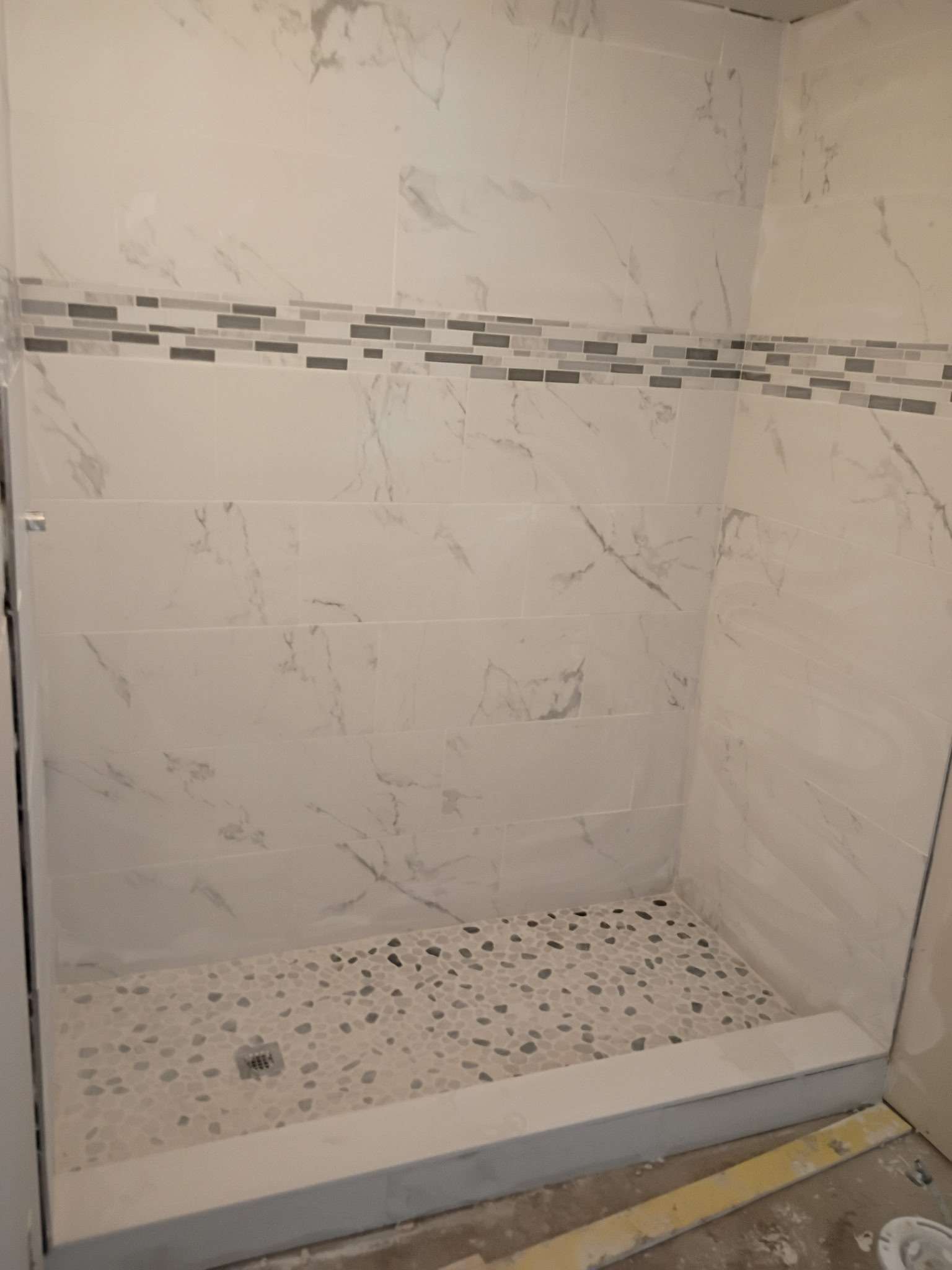 Shower with white marble-look tile before the remodel