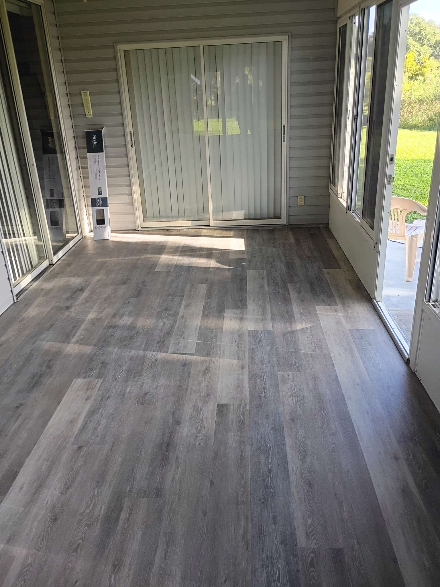 Sunroom with new vinyl plank flooring installed by Handy Handyman Services